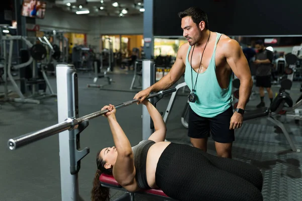 Şişman genç bir kadına ağırlık kaldırmayı açıklayan kişisel antrenör. Spor salonunda beden eğitimi koçu bir egzersiz rutini öğretiyor.