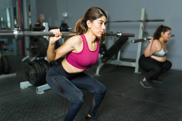 활동적 매력적 여자는 훈련을 체육관에서 역기를 들면서 있다고 느낀다 — 스톡 사진
