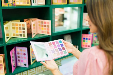 Makyaj reyonundaki bayan müşteri kozmetik ürünleri alırken görüldü. 