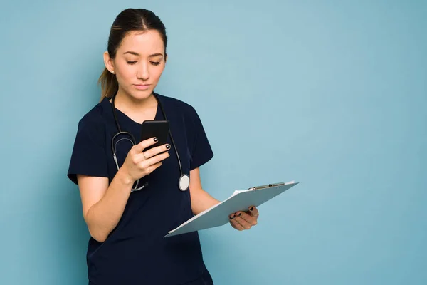 Serious Looking Female Doctor Looking Her Smartphone Checking Her Messages — Stock Photo, Image