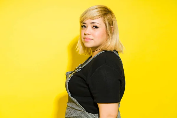 Good looking fat woman with dyed hair and casual clothing looking confident in a studio