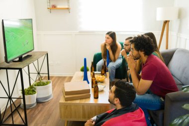 Latin bir grup arkadaş TV 'de maç izliyorlar ve maç için endişeleniyorlar.