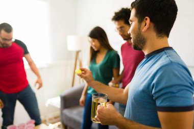 Yakışıklı İspanyol bir adam bir partide arkadaşlarıyla bira pong oynuyor ve çok eğleniyor. 