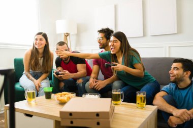 Latin kökenli genç kadınlar mutlu arkadaşlarıyla oyun maçı kazanıp bira içerek eğleniyorlar.