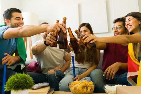 Amici Felici Clinking Loro Bottiglie Birra Mentre Appendere Insieme Salotto — Foto Stock