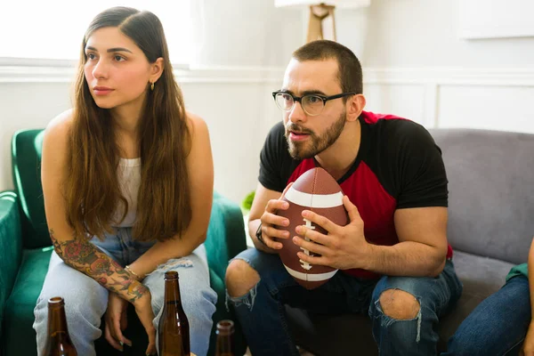 Stressed couple watching the football championship and supporting the national team