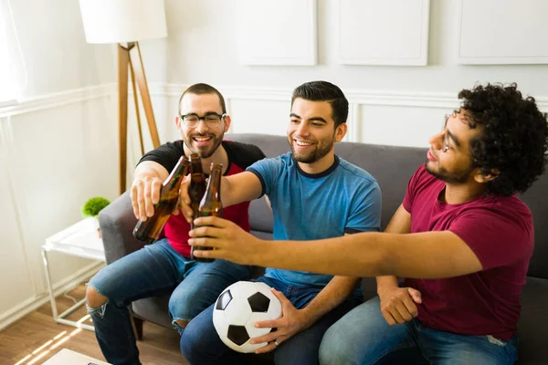 在电视上看体育比赛的时候 快乐的朋友们一边喝啤酒一边举杯 — 图库照片