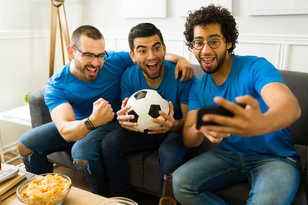 超级快乐的一群朋友一边笑一边自私自利 在客厅里看体育比赛 — 图库照片