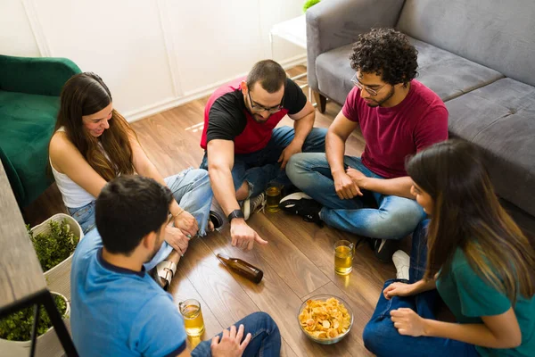 在一个有趣的派对上 很多年轻男女一边喝啤酒一边打转瓶子游戏 — 图库照片