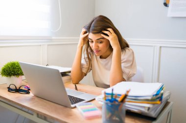 Stresli Latin kadın ofiste yaptığı bir sürü iş yüzünden bunalmış ve endişeli. 