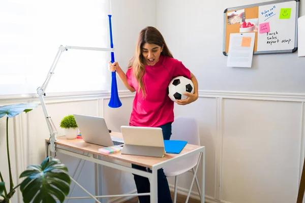 Anxious Woman Holding Soccer Ball Vuvuzela While Doing Remote Work — Stock Photo, Image