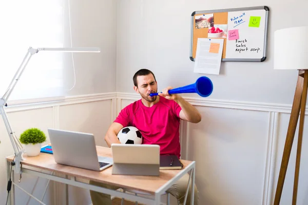 Cheerful Man Holding Soccer Ball Vuvuzela While Doing Remote Work — Stock Photo, Image