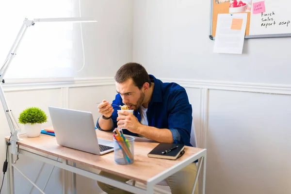 Jovem Faminto Almoçando Sua Mesa Enquanto Olha Para Computador Faz — Fotografia de Stock