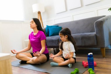 Rahat anne ve küçük çocuk evde çalışırken birlikte meditasyon yogası yapıyorlar. 