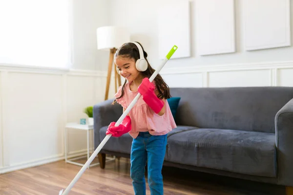 Hispanic Little Girl Years Listening Music Headphones While Sweeping Helping —  Fotos de Stock