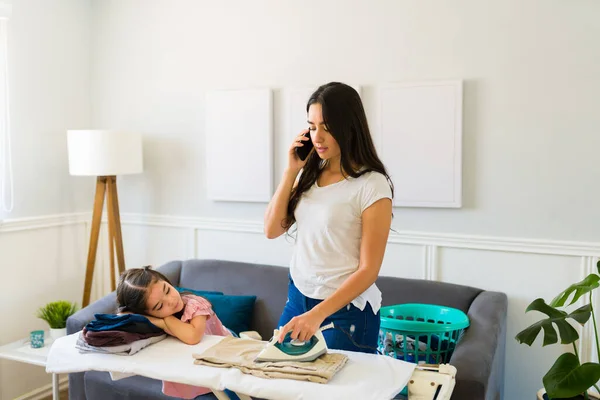 Busy Hispanic Mother Talking Phone Ironing Clothes While Doing Lot — Stock Photo, Image