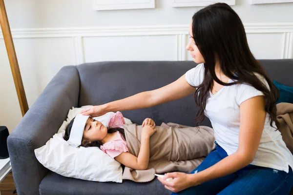 Niña Enferma Con Fiebre Resfriado Descansando Sofá Con Madre Hispana —  Fotos de Stock
