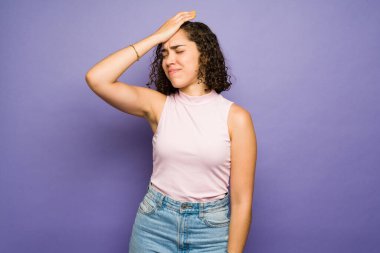 Sıkıntılı, üzgün bir kadın. Bir şey yapmayı unuttuktan sonra elini alnına koyuyor ve endişeleniyor. 