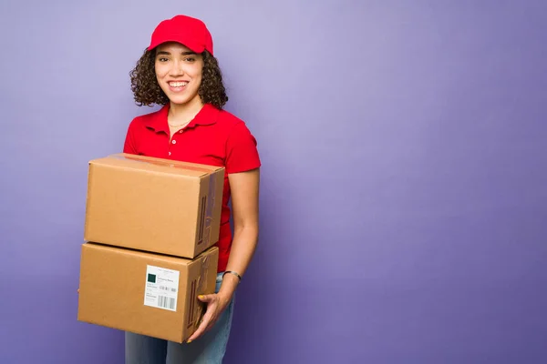 Cheerful Brunette Woman Red Uniform Smiling Carrying Lot Packages Working — Φωτογραφία Αρχείου
