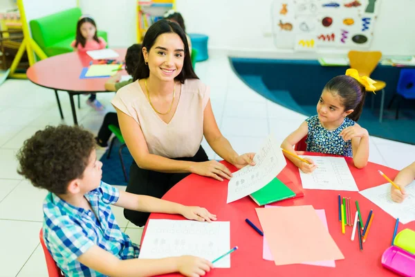 Attractive Woman Teacher Smiling Making Eye Contact While Sitting Her —  Fotos de Stock