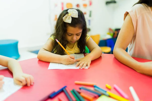 Entschlossenes Kleines Mädchen Das Schreibtisch Sitzt Und Während Einer Vorschulstunde — Stockfoto