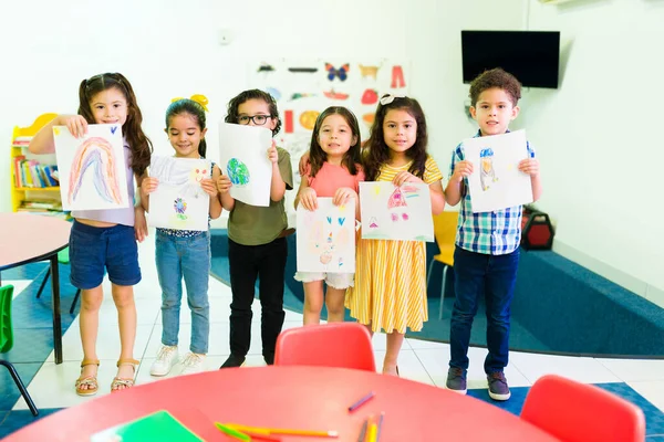Urocza Wielorasowa Grupa Przedszkolaków Pokazująca Swoje Rysunki Zajęciach Plastycznych Bardzo — Zdjęcie stockowe