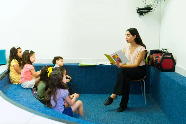 Beautiful Kindergarten Teacher Reading Children Book Preschool Boys Girls Students — Zdjęcie stockowe