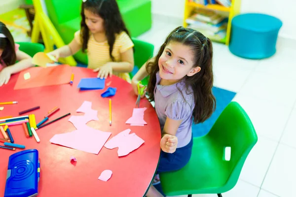 Adorable Preschool Girl Smiling Making Eye Contact While Sitting Her — Foto Stock