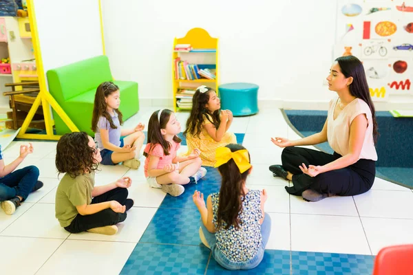 Zrelaksowany Nauczyciel Przedszkola Robi Medytację Ćwiczenia Oddechowe Podczas Relaksu Dziećmi — Zdjęcie stockowe