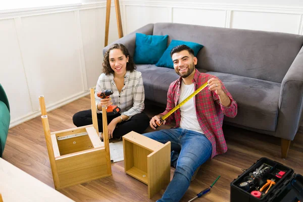 Cheerful Young Couple Smiling Looking Camera While Enjoying Assembling Furniture — Stok fotoğraf