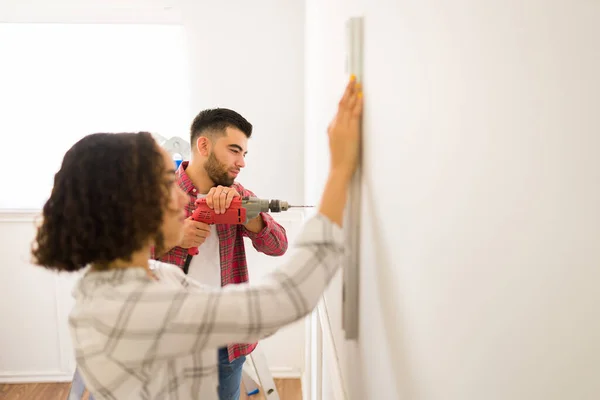 Side View Young Couple Drilling Wall Working Together While Doing — стоковое фото