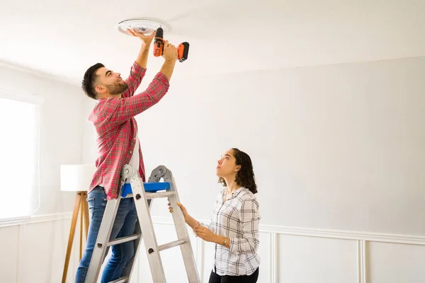 Happy Young Man Drilling Ceiling Putting New Lamp Lighting His — Zdjęcie stockowe
