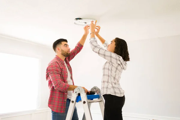 Handy Young Couple Standing Ladder Repairing Lighting Electricity House — Stock Photo, Image