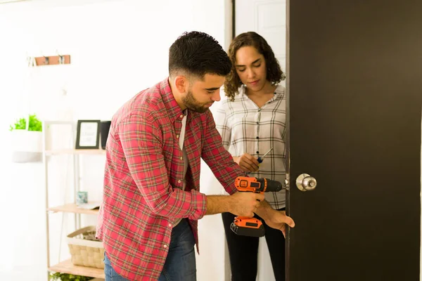 Handy Young Man Woman Putting New Security Doorknob Drill Door — стоковое фото