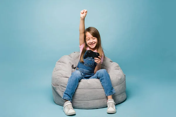 Весела Маленька Дівчинка Піднімає Кулак Посміхається Під Час Святкування Виграшу — стокове фото