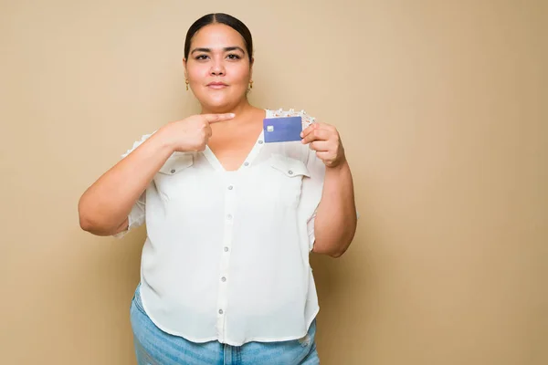 Привлекательная Женщина Ожирением Смотрит Камеру Указывая Свою Кредитку Ходить Магазинам — стоковое фото