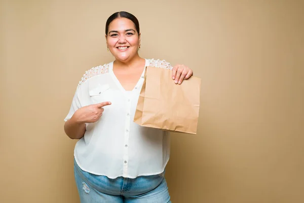Взволнованная Толстая Женщина Заказывающая Еду Доставки Указывающая Бумажный Пакет Едой — стоковое фото