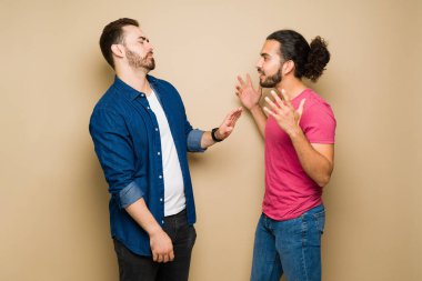 Angry hispanic man arguing with his caucasian gay boyfriend during a fight because of communication problems