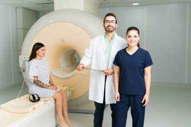 Portrait of a happy doctor and radiologist smiling while waiting with a patient after doing a magnetic resonance medical exam