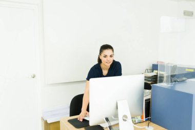 Attractive female radiologist checking the test results of a patient in the computer at the diagnostic imaging center 