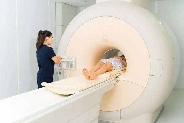 Female Radiologist Technician Starting Button Mri Machine While Doing Brain — Stockfoto