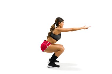 Side view of an active latin woman working out and doing squat exercises for her cross-training routine