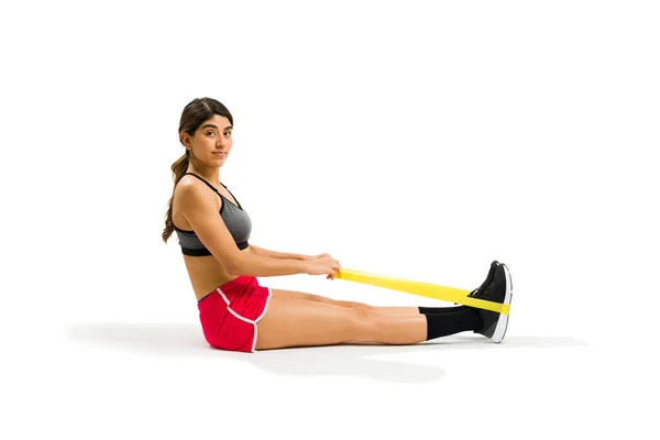 Hispanic Young Woman Looking Camera While Pulling Resistance Band While —  Fotos de Stock