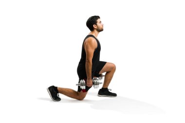 Side view of a handsome fit man working out and doing leg lunges exercises while using dumbbell weights