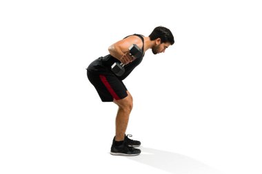 Sporty young man lifting weights and doing dumbbell row exercises during his workout routine