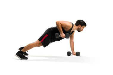 Handsome hispanic man doing push up exercises with dumbbell weights for his cross training workout