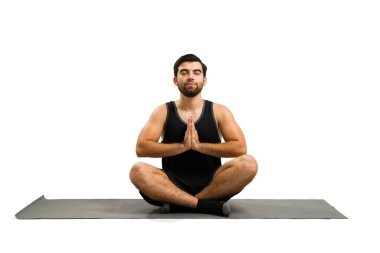 Relaxed attractive man meditating and doing breathing exercises after finishing his yoga workout