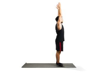Active man doing a sun salutation while exercising with a yoga workout in front of a white background with copy space
