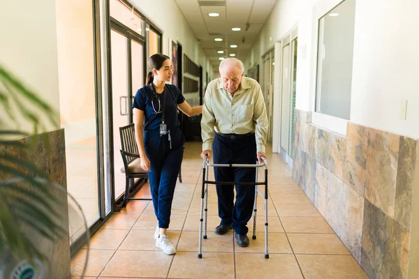 Caring Female Nurse Helping Retired Old Man Using Walker While — Stock Photo, Image