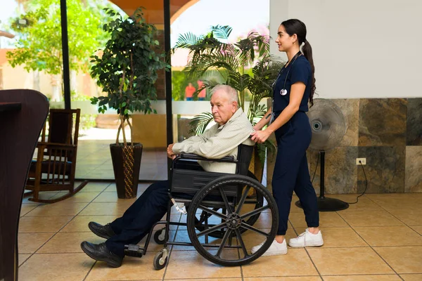 Side View Beautiful Female Nurse Pushing Wheelchair Disabled Mature Retired — Stock Photo, Image